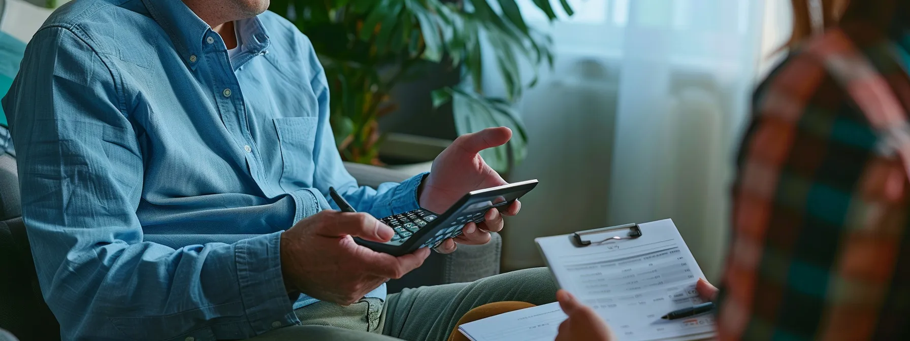 a person holding a calculator while discussing therapy costs with a therapist.