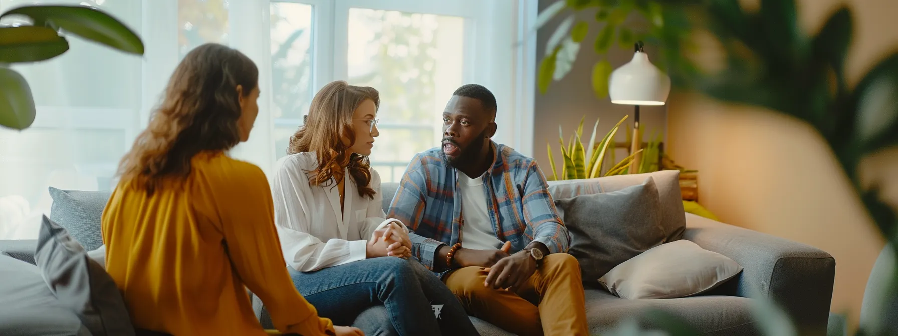 a couple sitting close together on a comfortable couch, deep in conversation with a compassionate therapist.